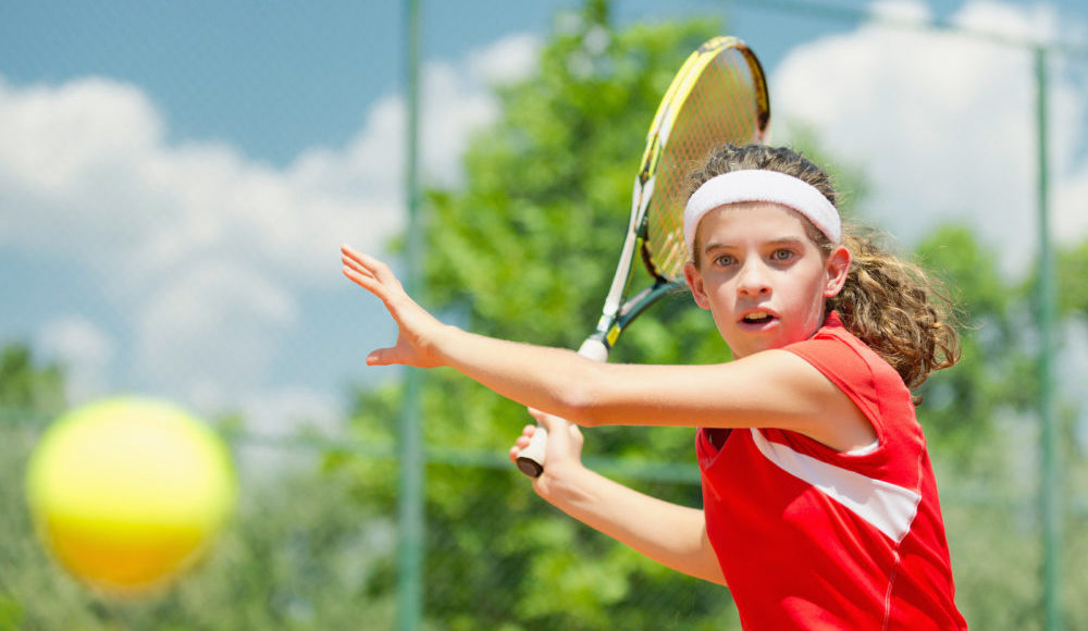 Young tennis champion hitting forehand, toned image